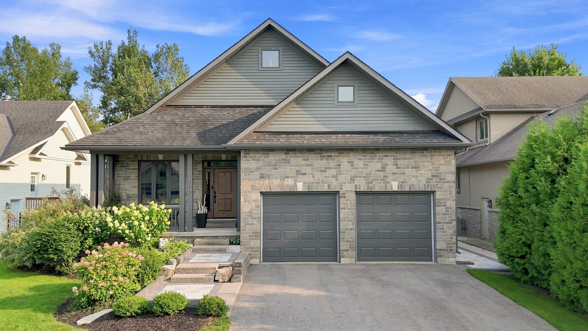 Front exterior of 110 Mary Street, a custom stone-and-siding bungalow in Collingwood, Ontario